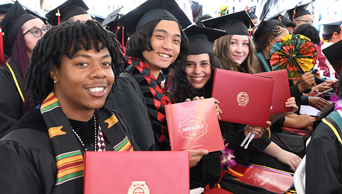 Group of graduates holding degrees